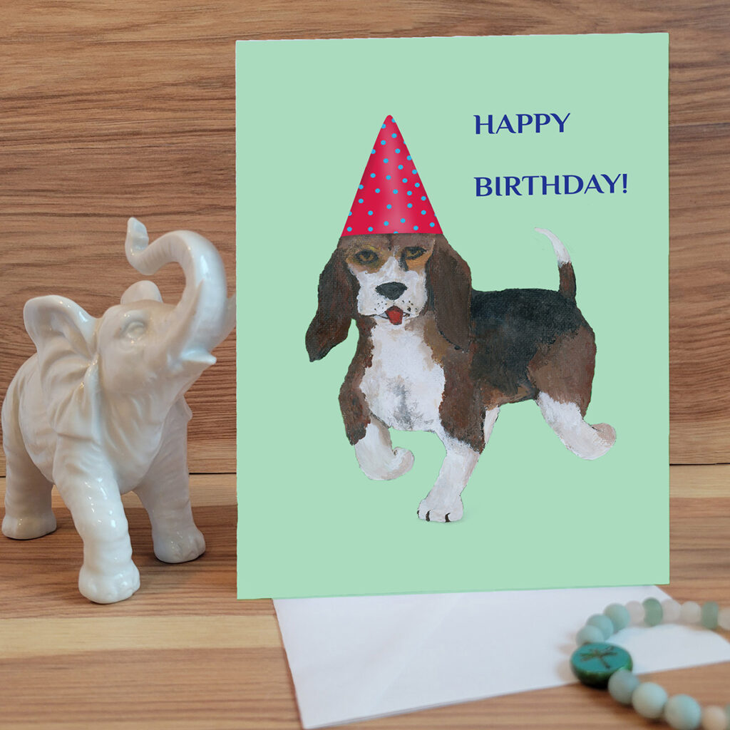 Birthday Card with a trotting Beagle dog wearing a birthday hat.