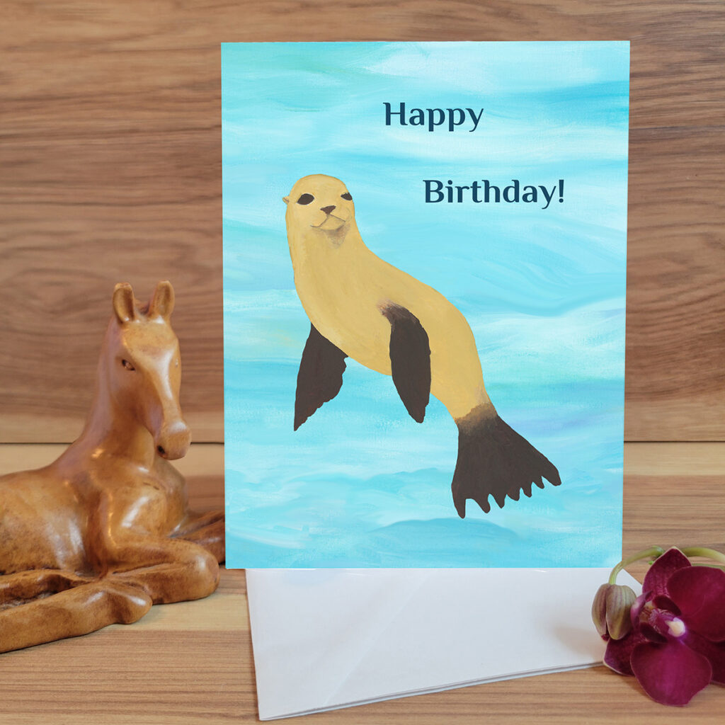 Seal floating in water with birthday wishes.