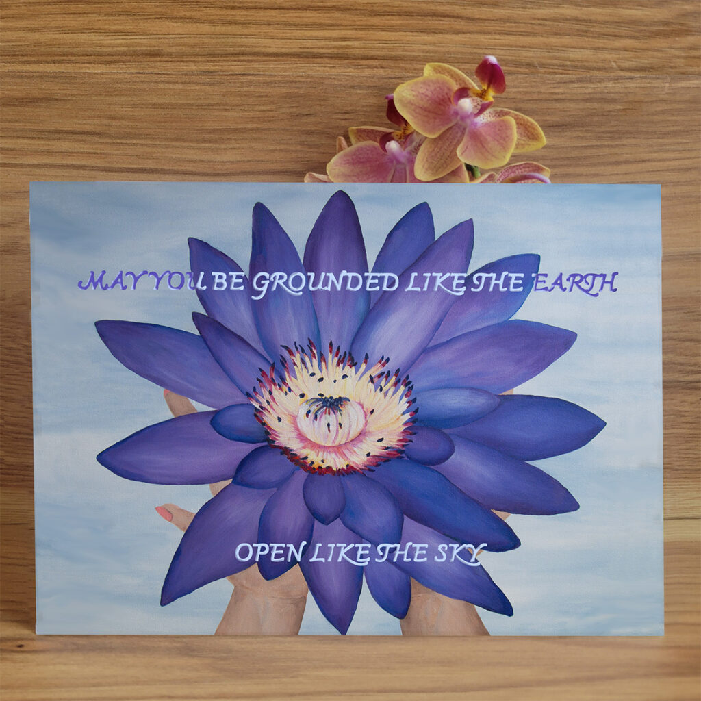 purple lotus flower laying in the palm of hands. Words say, "May you be grounded like the Earth and open like the sky.