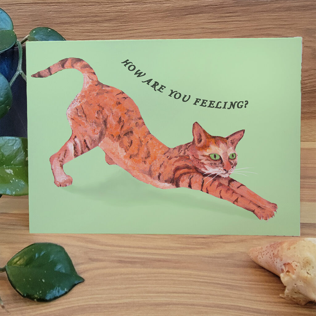 Orang Cat stretching into a downward dog. Card says "How are you Feeling?"